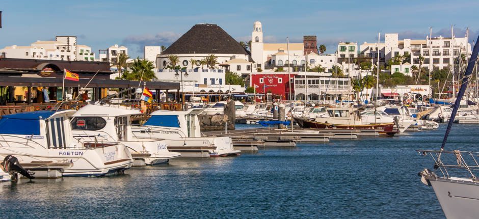 The marina of Playa Blanca with boats and white buildings